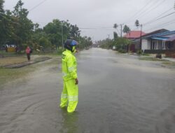 Hujan Tak Menyurutkan Semangat Personel Polsek Pasangkayu Pantau Luapan Air di Sepanjang Jalan Anjungan